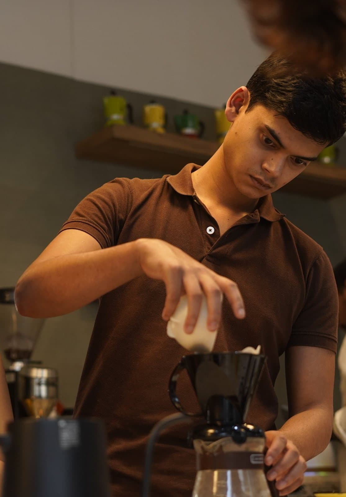 Students at the academy bar making pour-over coffee.